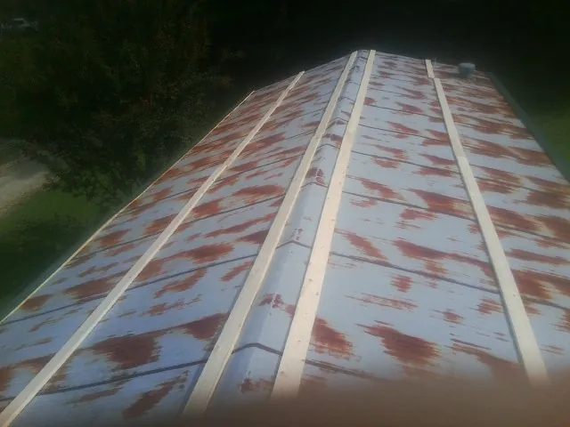 Rusted metal roof panels with new wood purlins before replacement — Storm Damage Roof Repair in Beach by Roofing Brothers