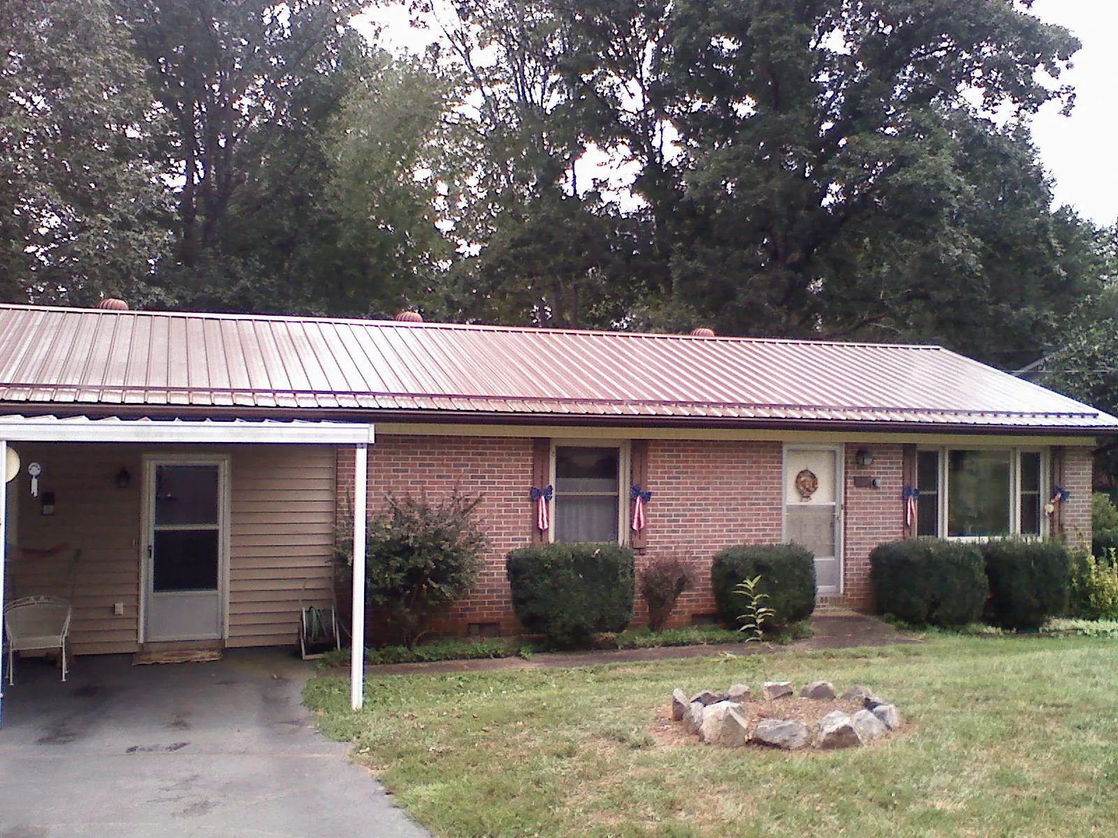 Bronze metal roof and carport on a brick ranch home — Roof Repair work by our crew in Beach