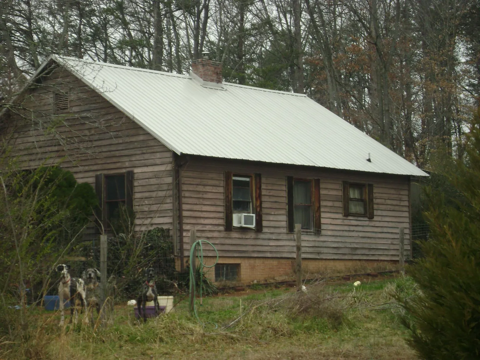 White metal roof on an old wood sided farmhouse, from a Metal Roof Installation job in Beach
